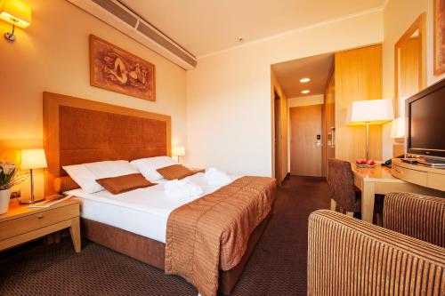 a hotel room with two beds and a television at Grand Hotel Primus - Terme Ptuj - Sava Hotels & Resorts in Ptuj