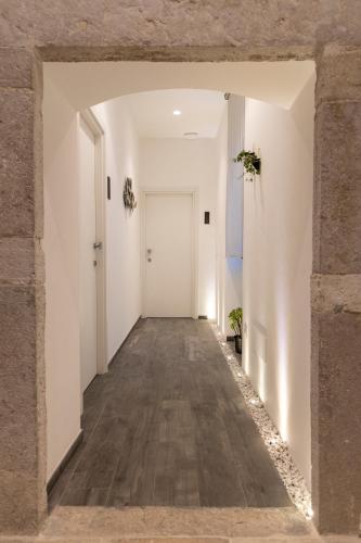 an empty hallway with white walls and a white door at Porta Vetere - Boutique Rooms in Trani