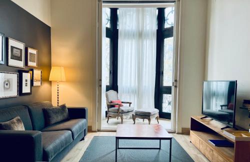 a living room with a couch and a tv at Apartments Sixtyfour in Barcelona