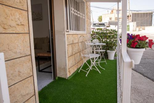 a patio with a table and chairs on the grass at רוזמרין בחרמון in Majdal Shams