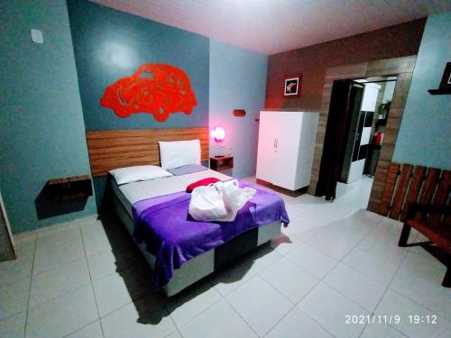 sypialnia z łóżkiem z czerwoną rybą na ścianie w obiekcie Casal.20 Studios Flats w mieście Cabo de Santo Agostinho