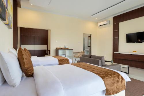 a hotel room with two beds and a television at Semabu Hills Hotel Nusa Penida in Nusa Penida