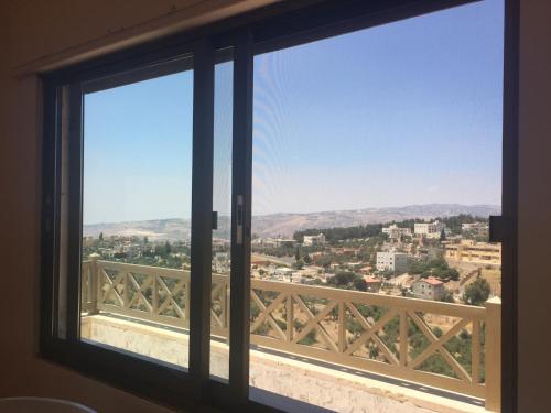 a window with a view of a city at Charming House in Amman + Balcony in Amman