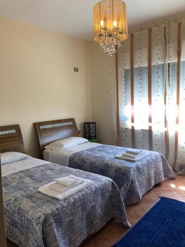 a bedroom with two beds and a chandelier at Charming House in Amman + Balcony in Amman