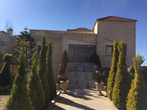 a house with a bunch of trees in front of it at Charming House in Amman + Balcony in Amman