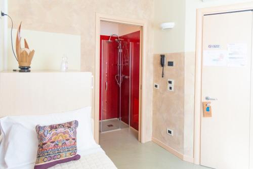 a bathroom with a red shower and a pillow at Affittacamere Bardolino in Calmasino