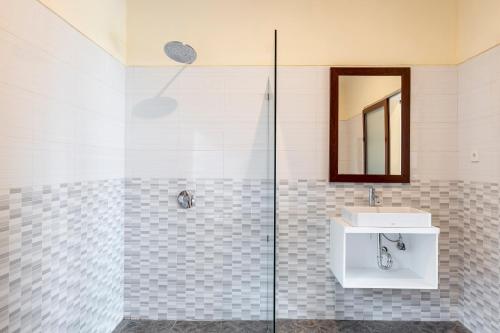 a bathroom with a shower with a sink and a mirror at Semabu Hills Hotel Nusa Penida in Nusa Penida