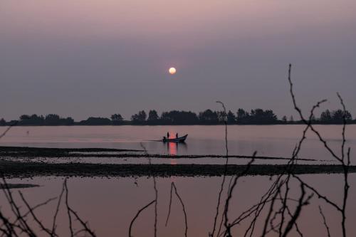 two people in a boat on the water at sunset at The Alampara Resort - Luxury Boutique Glamping & Water sports in Cheyūr