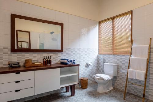 a bathroom with a toilet and a mirror at Semabu Hills Hotel Nusa Penida in Nusa Penida