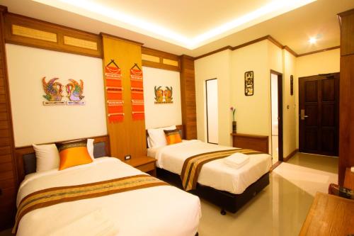 a hotel room with two beds in a room at Lee Chiang Hotel in Chiang Mai