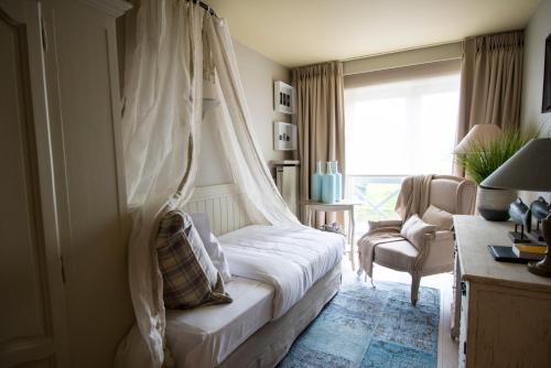 a bedroom with a bed with a mosquito net at Lebeaubylivingroom Hotel in Knokke-Heist
