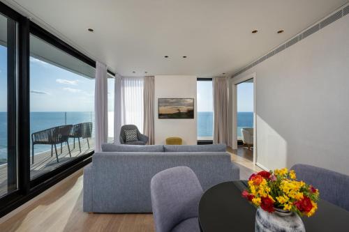 a living room filled with furniture and a view of the ocean at Vert Lagoon Netanya in Netanya