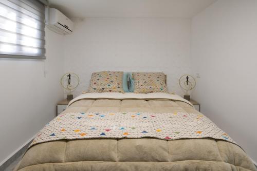 ein Schlafzimmer mit einem großen Bett mit zwei Lampen in der Unterkunft Apartment with jacuzzi & pool table, Haifa center close to Bahai Garden in Haifa