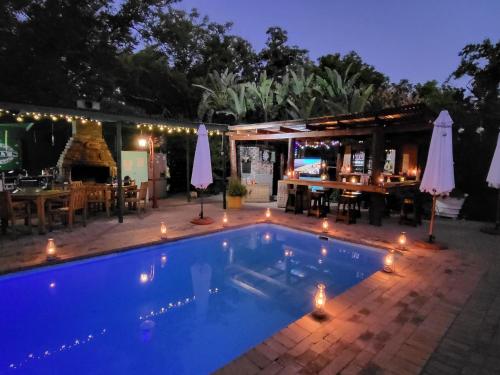 a swimming pool at night with a restaurant at Rosenhof Loft Cabins in Clanwilliam
