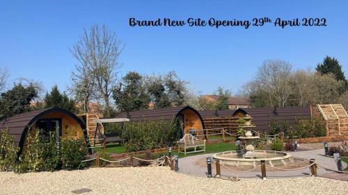 a garden with several buildings and a fountain in the yard at Peacock Lake Glamping in Nottingham