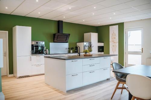 a kitchen with white cabinets and a table with chairs at XXL Ferienhaus Goldberger See - Sauna - 16 Personen in Goldberg