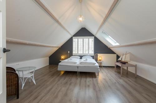 een slaapkamer op zolder met een bed en een tafel bij Vebenabos 36 in Koudekerke