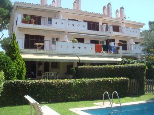 a large building with a swimming pool in front of it at Apartamento Playa in S'Agaro