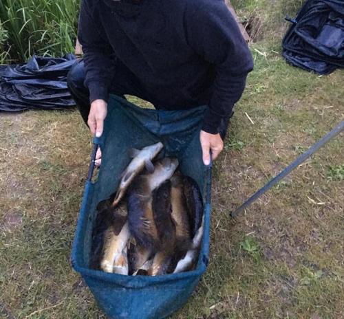 a person is holding a basket of fish at Peacock Lake Glamping in Nottingham