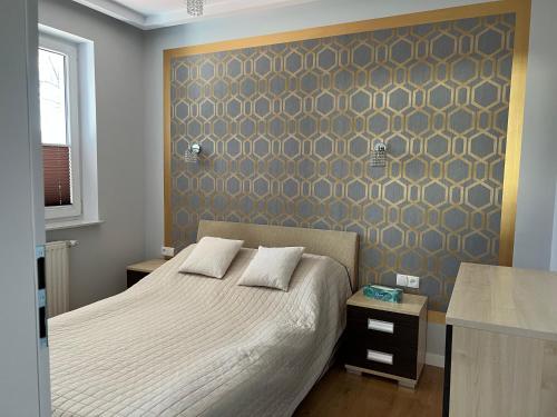 a bedroom with a bed and a wall with a pattern at Apartament Przy Plaży in Gdańsk