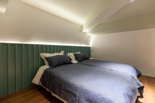 a bedroom with a bed with a green wall at Spa & Pool - Studio Apartments 365 in Tirana
