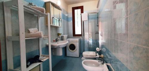 a bathroom with a sink toilet and a washing machine at Via Ugento Apartments - GiHome in Sant'Isidoro