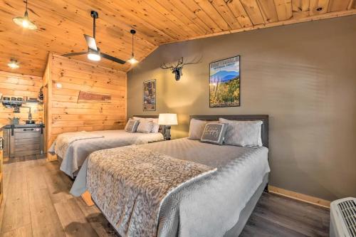 two beds in a room with wooden walls and wooden floors at The Lodge Nantahala River in Bryson City