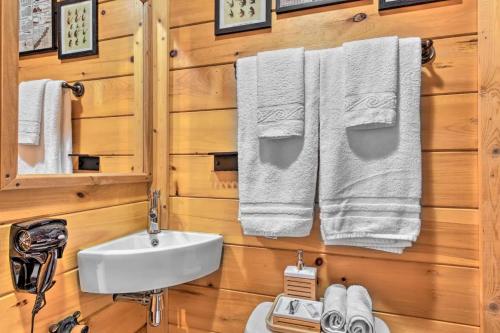 a bathroom with a sink and towels on a wooden wall at The Lodge Nantahala River in Bryson City