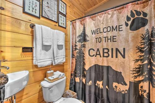 a bathroom with a shower curtain with a welcome to the cabin at The Lodge Nantahala River in Bryson City