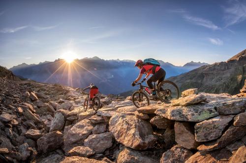 dos personas montando bicicletas en una montaña rocosa en Hotel Valentin en Sölden