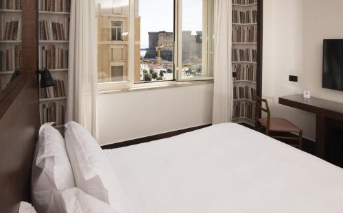 a bedroom with a white bed and a window at Domus Vista Castello in Naples