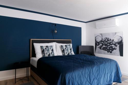 a bedroom with a blue accent wall and a bed at KRACHER Landhaus No 2 - inklusive Pool in Illmitz