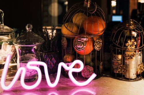 a neon sign that says faith in front of glass jars at Il Fogliano Hotel New Life in Latina