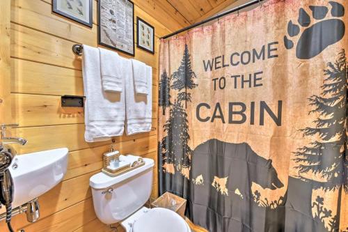 a bathroom with a toilet and a welcome to the cabin shower curtain at The Lodge Nantahala River in Bryson City