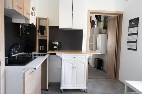a kitchen with white cabinets and a sink at Stylowy apartament w historycznej części Gdańska in Gdańsk