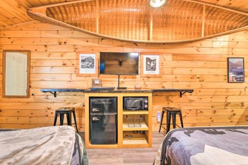 a bedroom with two beds and a tv in a wooden cabin at The Lodge Nantahala River in Bryson City