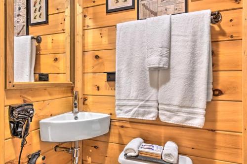 a bathroom with a sink and towels on a wooden wall at The Lodge Nantahala River in Bryson City