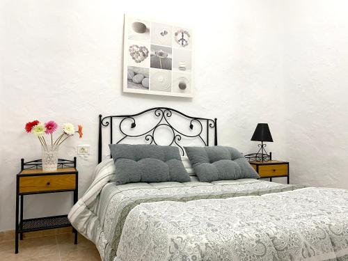 1 dormitorio con 1 cama con 2 mesitas de noche y 2 mesas en 4 bedrooms house with enclosed garden and wifi at Ingenio, en Ingenio