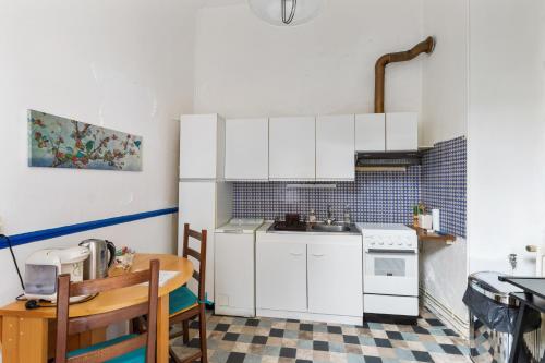 une petite cuisine avec des armoires blanches et une table dans l'établissement Appartement confortable à Sens - 40 m² + jardin, à Sens