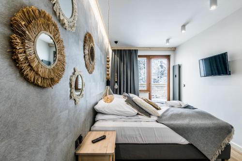 a bedroom with a bed and mirrors on the wall at Apartament Forrest Pardałówka in Zakopane