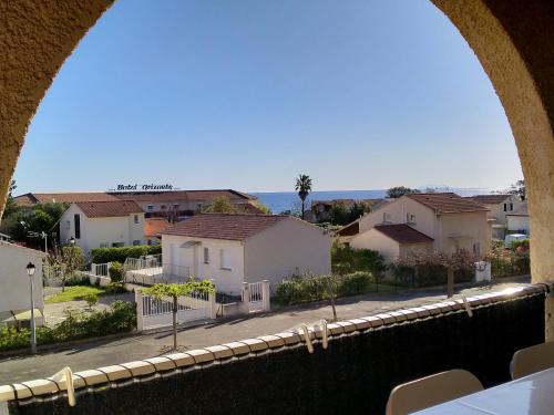 a view from an archway of a street with houses at studio à 100m de la plage et de la piscine in Cervione