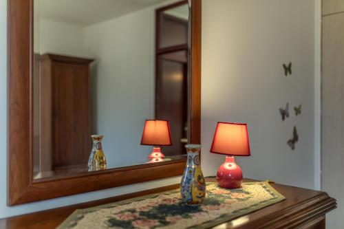 a table with a mirror and two lamps on it at barapartman_centar in Bar