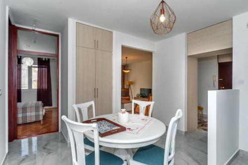 a kitchen and dining room with a white table and chairs at barapartman_centar in Bar