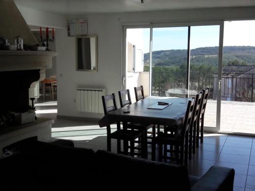 une salle à manger avec une table et des chaises et une cheminée dans l'établissement VIDAL BERNARD, à Saint-André-de-Vézines