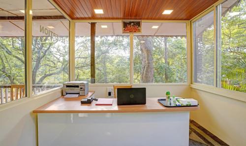 马泰兰Treebo Cecil Resort, 600 Mtrs From Matheran Railway Station的办公室,办公桌,电脑和窗户