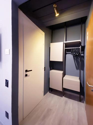 a walk in closet with a white door and hangers at Hotel Astoria in Garda