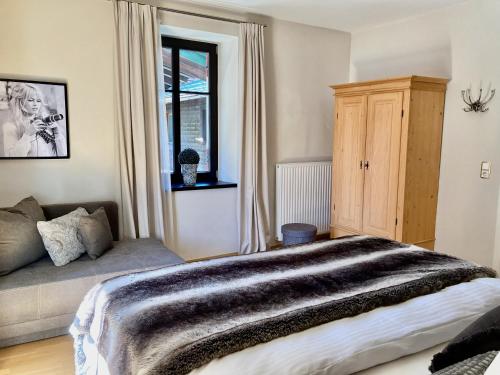 a bedroom with a bed and a window at STADTVILLA BELLE KITZ im Zentrum mit Sauna by Belle Stay in Kitzbühel