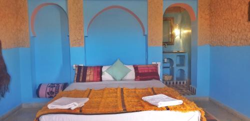 a bedroom with a bed with two towels on it at Kasbah Azalay Merzouga in Merzouga