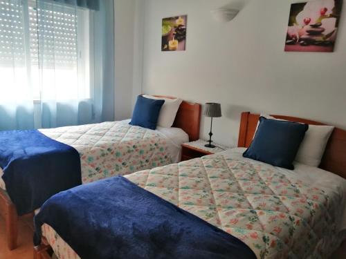 Un dormitorio con dos camas y una ventana. en Burgau Mar, en Burgau