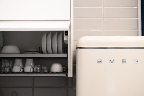 a refrigerator in a kitchen with plates and dishes at VILLA IN BED in Quarto